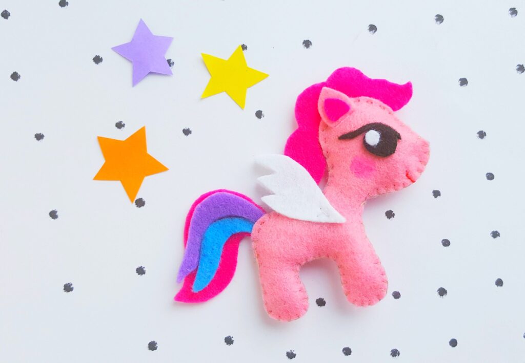 A pink felt pony surrounded by stars and polka dots.