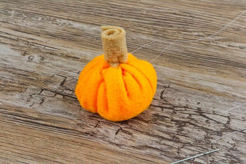 mini felt pumpkin on table with rolled stem sewn