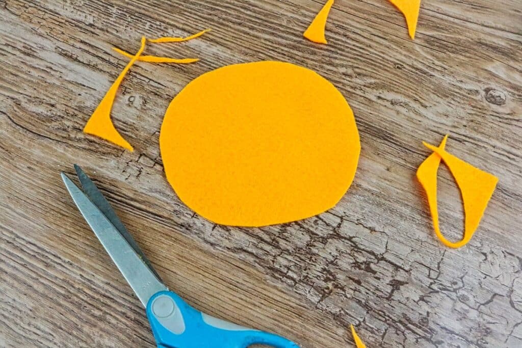 mini felt pumpkin on table cutout with scissors