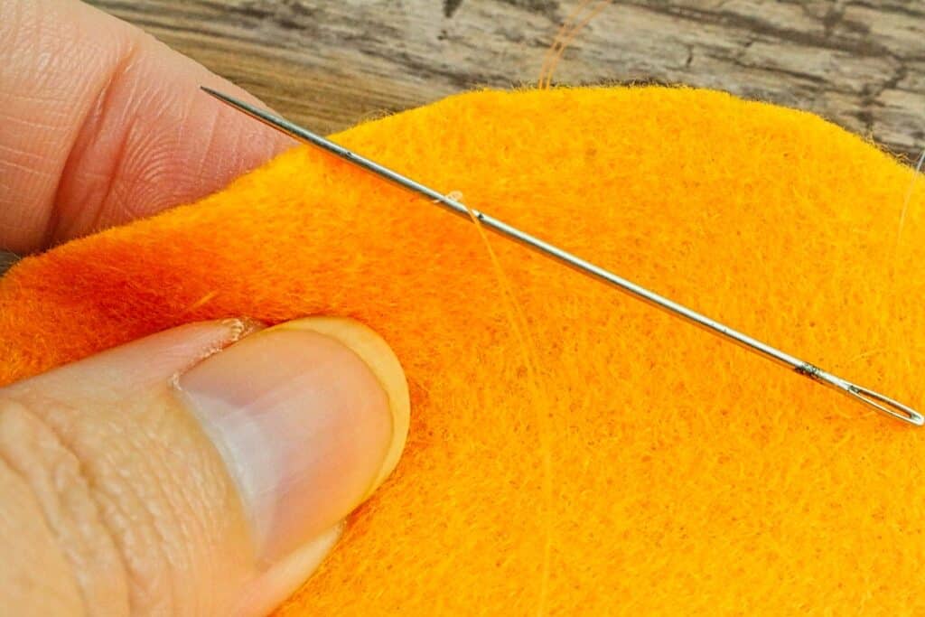 mini felt pumpkin sewn with thread around edge
