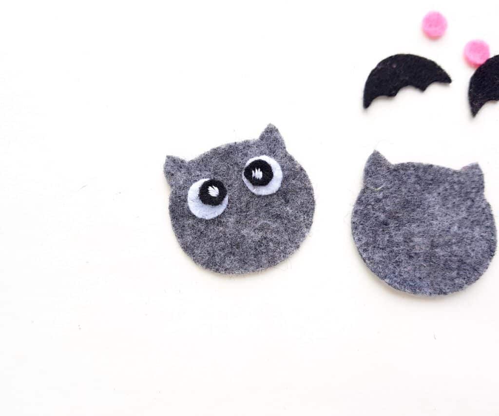 applying facial features to grey felt plush bat doll