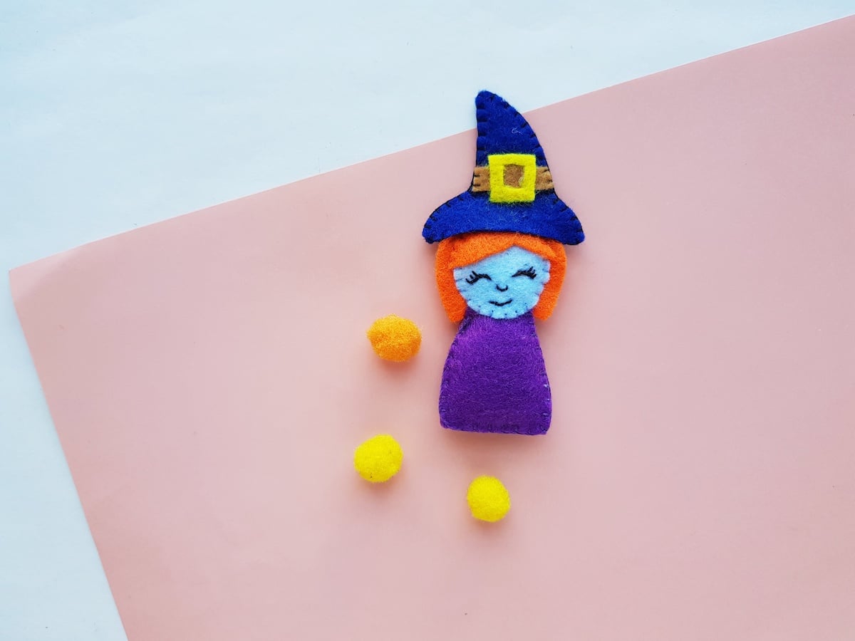 Witch Plush Doll completed with yellow pom poms on table