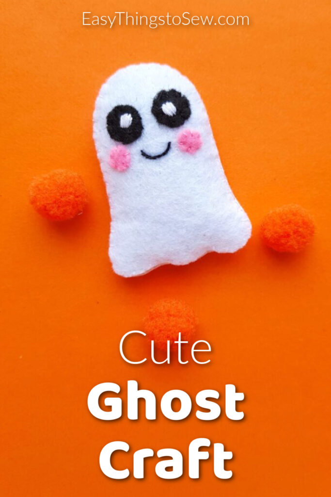 Felt ghost plush with three orange pom-poms on an orange background.