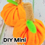 Two small, handmade felt pumpkins with cotton ball stuffing. Each has a green felt leaf and brown felt stem, placed on a rustic white wood surface. Text reads: "Sew a Mini Pumpkin Using Cotton Balls.