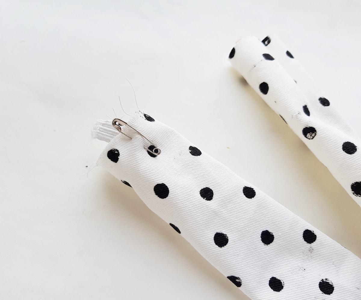 A pair of polka dot leggings on a white surface with a scrunchie.