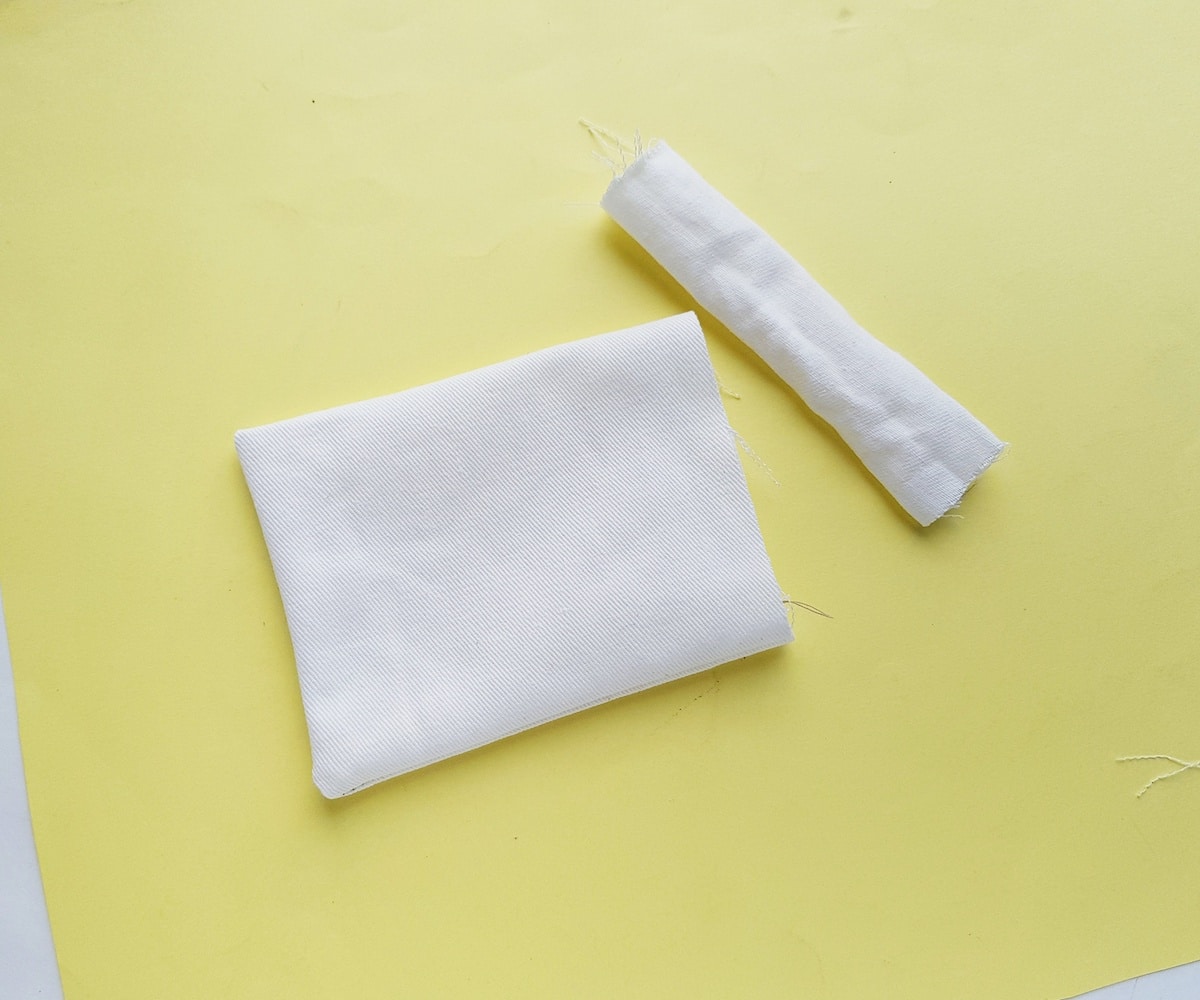 A white fabric with a yellow bow on top.