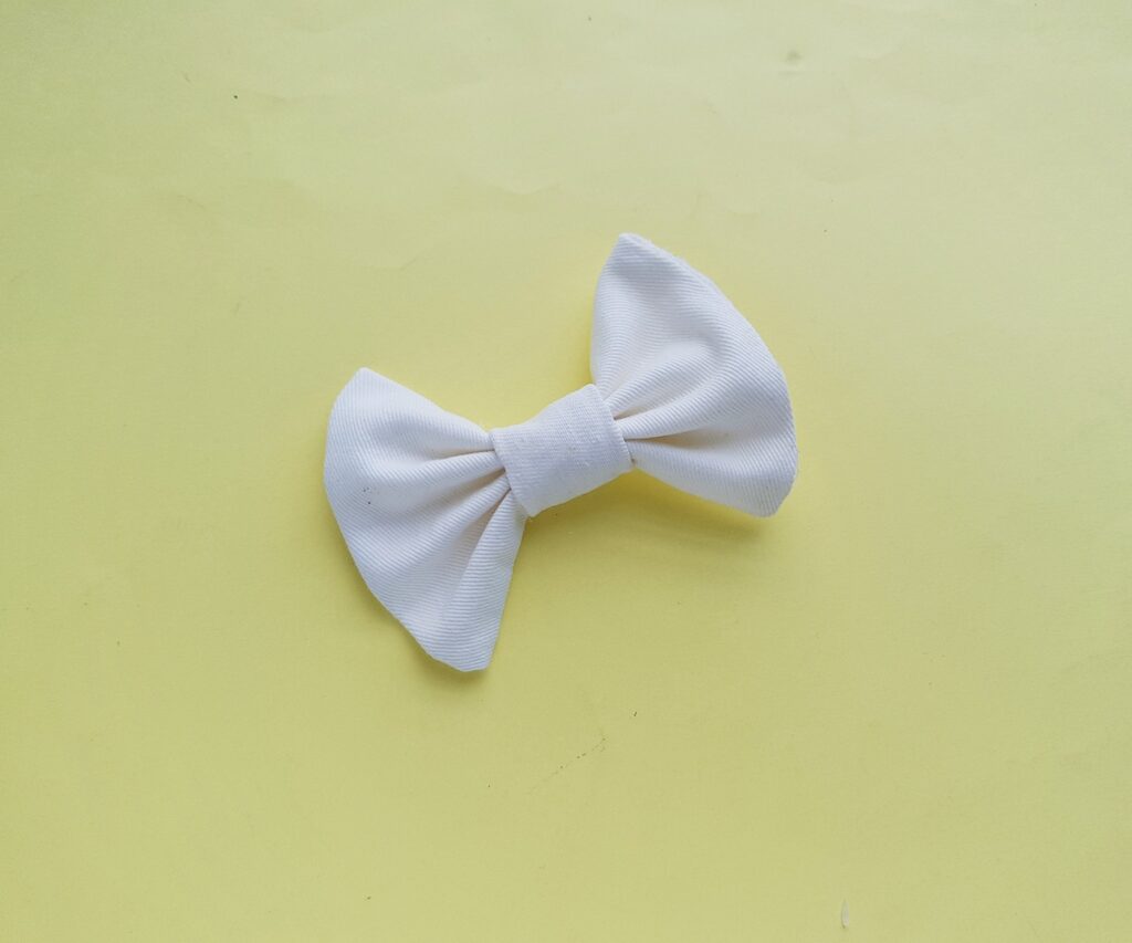 A white bow on a yellow background.