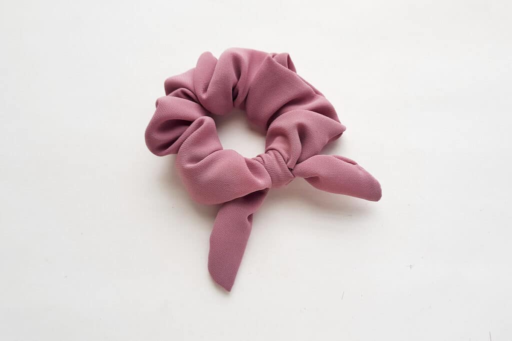 Bow Scrunchie Step 12 A pink scrunchie on a white surface.