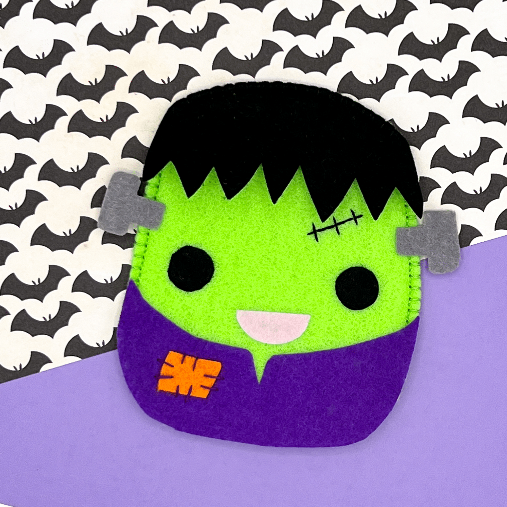 A felt Frankenstein candy pouch on a purple background.