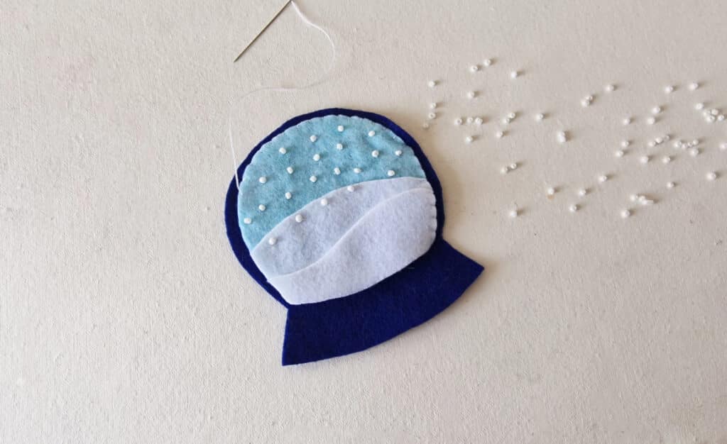 A felt ornament with a blue and white snowflake on it.