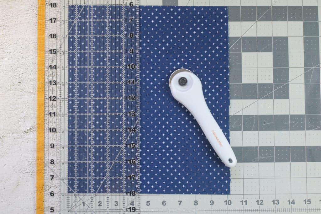 A ruler on a cutting mat next to a polka dot fabric.