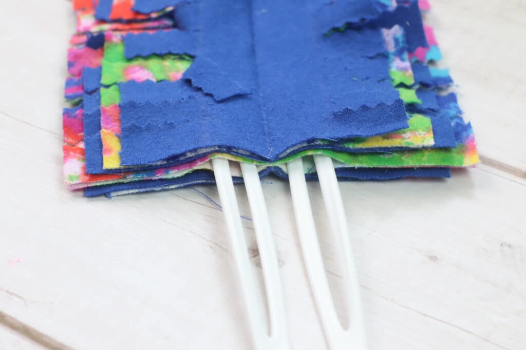 A pair of scissors and a piece of fabric on top of a wooden table.