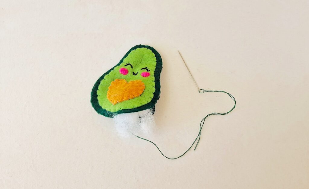 Step 10 A felt avocado with a needle attached to it.