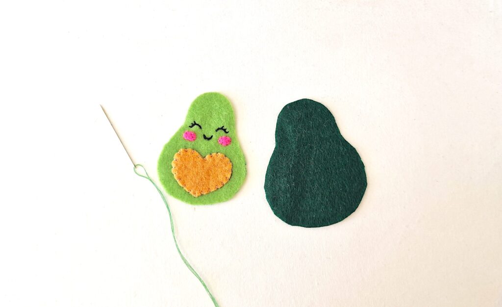 Step 6 Two felt avocados on a white surface.