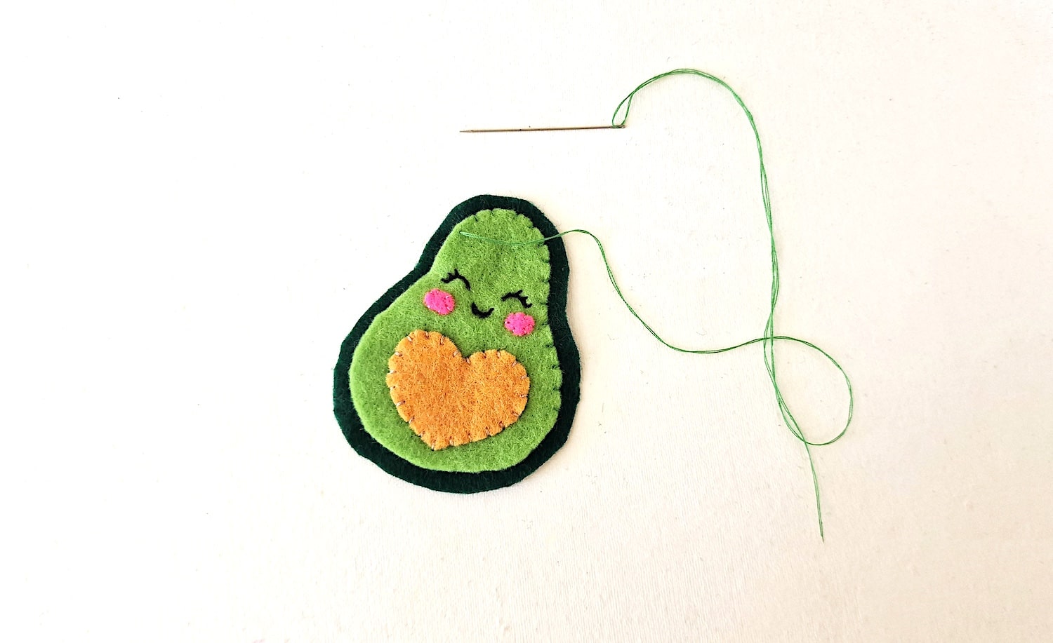 Step 7 A felt avocado with a thread attached to it.