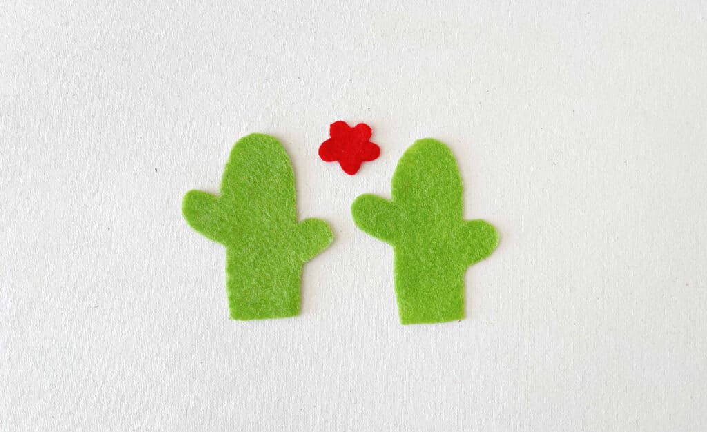 Two green felt cactus with a red flower in the middle.