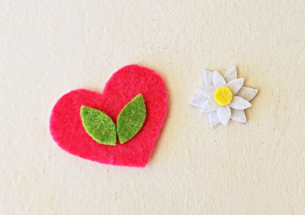 A heart and a flower on a white surface.