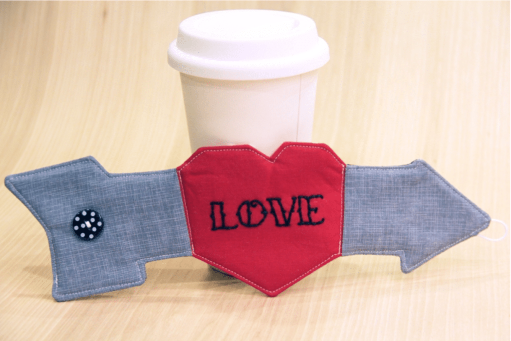 A coffee mug with the word love embroidered on it.
