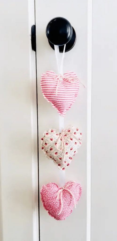 Three pink and white hearts hanging on a door.