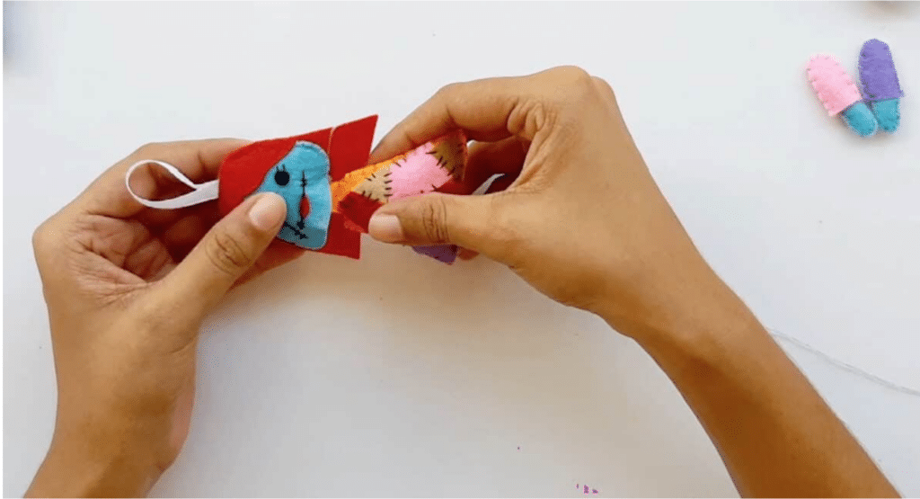 A person is making an ice cream cone out of colored paper.