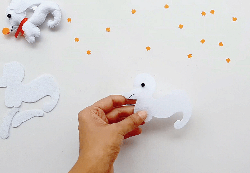 A person is making a ghost out of felt.