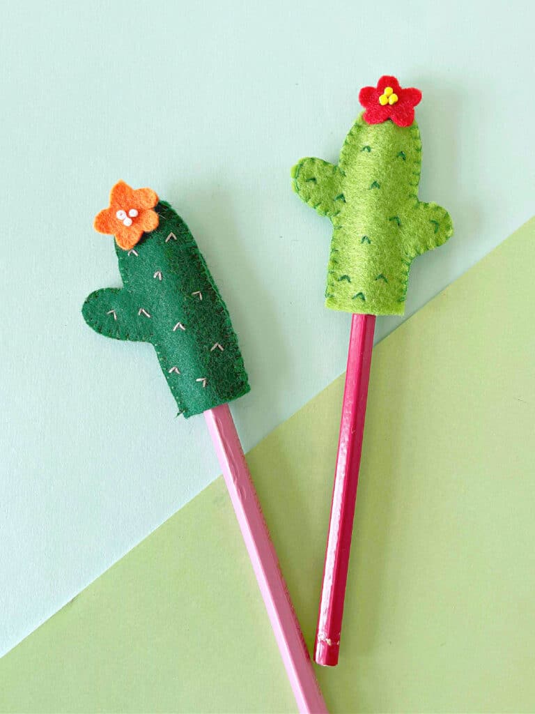 Two felt cactus pencil toppers with flowers.