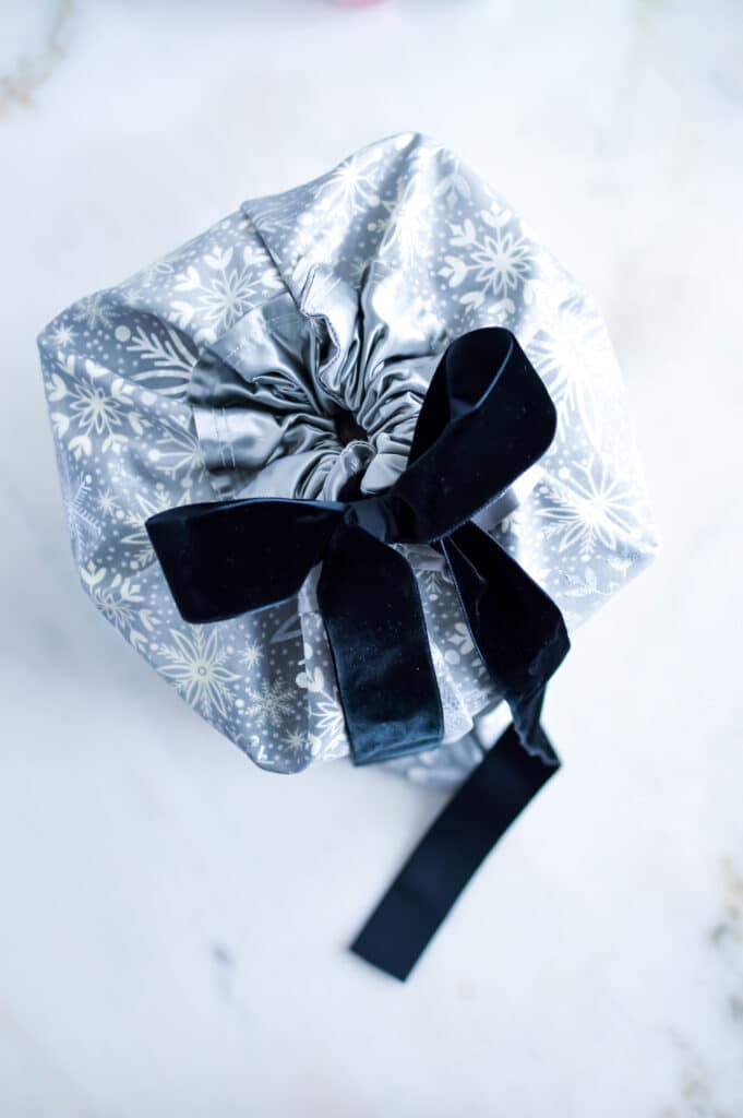 A silver gift wrap with a black bow.