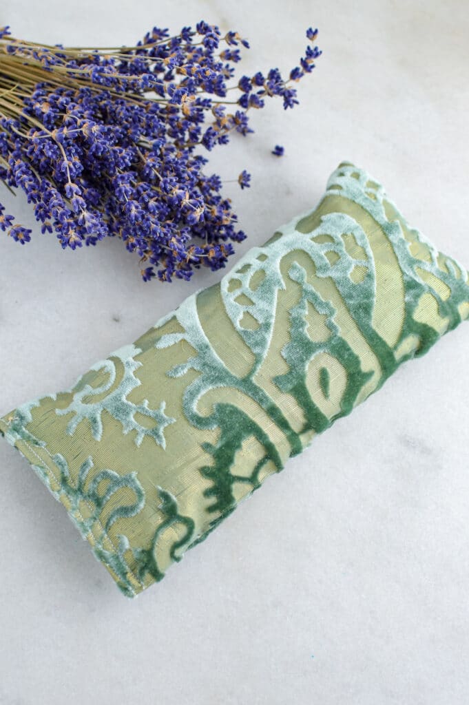 A green diy eye pillow with lavender flowers on it.