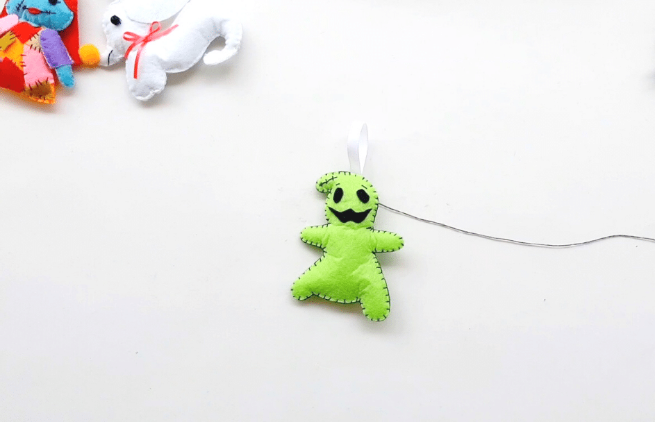 A green stuffed animal hanging on a string.