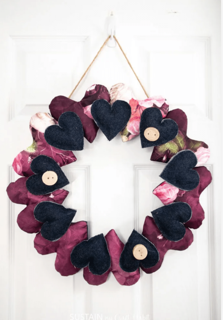 A heart wreath with buttons hanging on a door.