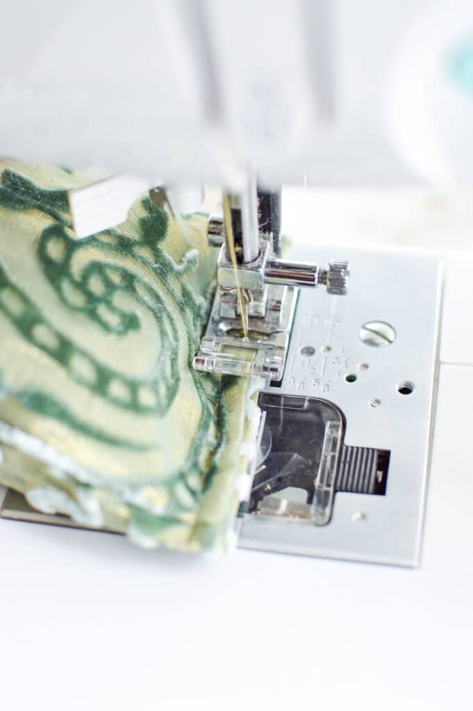 A sewing machine is being used to sew a diy eye pillow made of fabric.