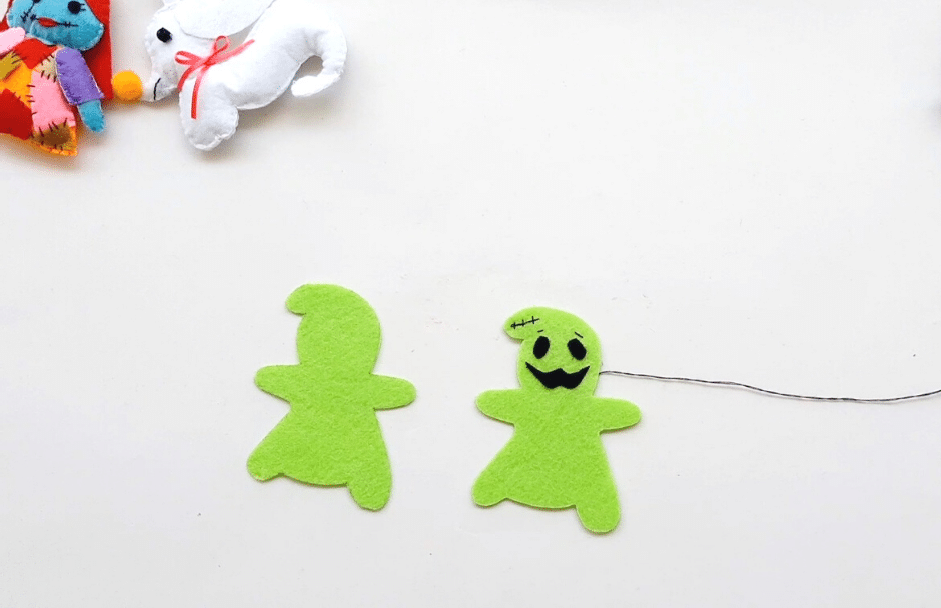 A group of green felt ghosts on a white table.