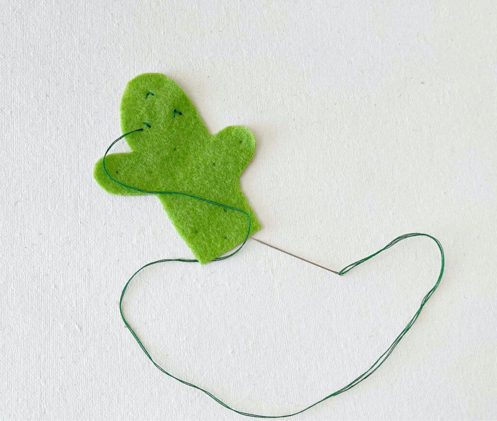A green felt cactus hanging on a string.