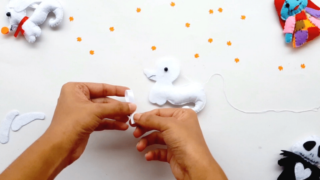 A person is making a stuffed animal out of yarn.