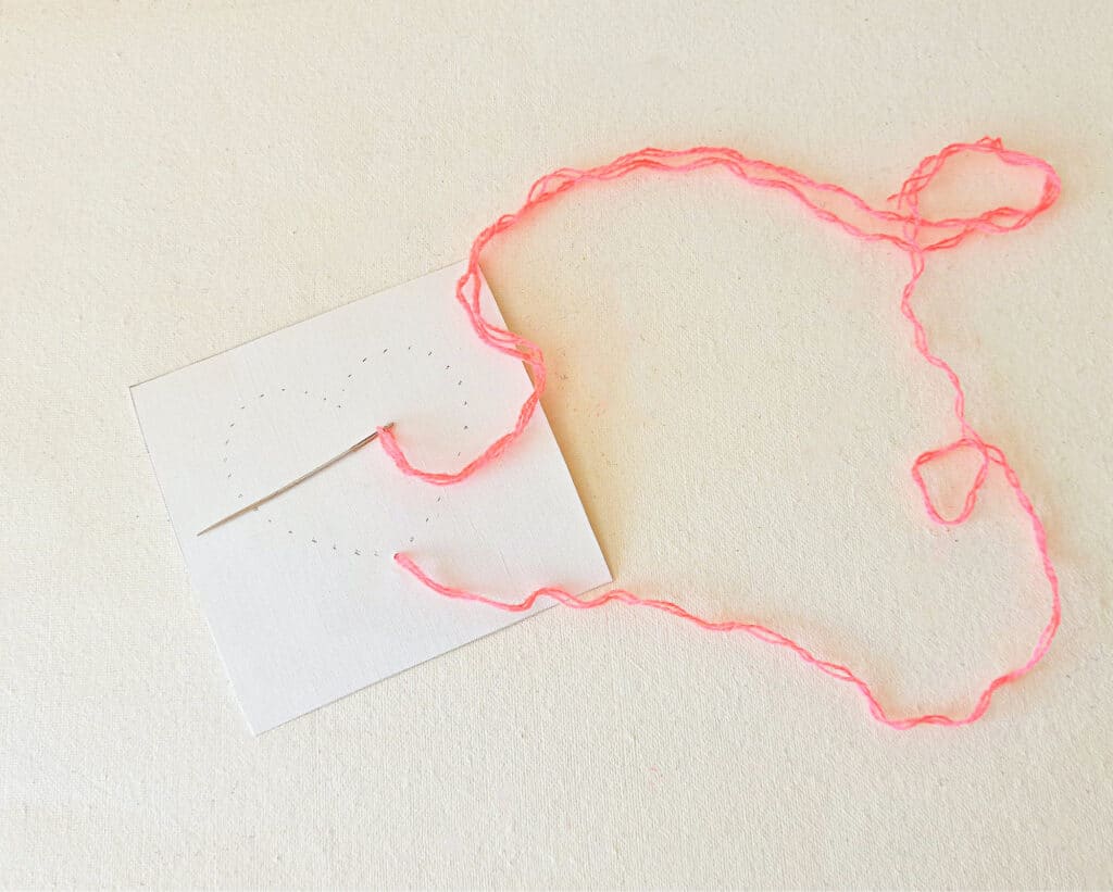 A piece of paper with a pink string on it.
