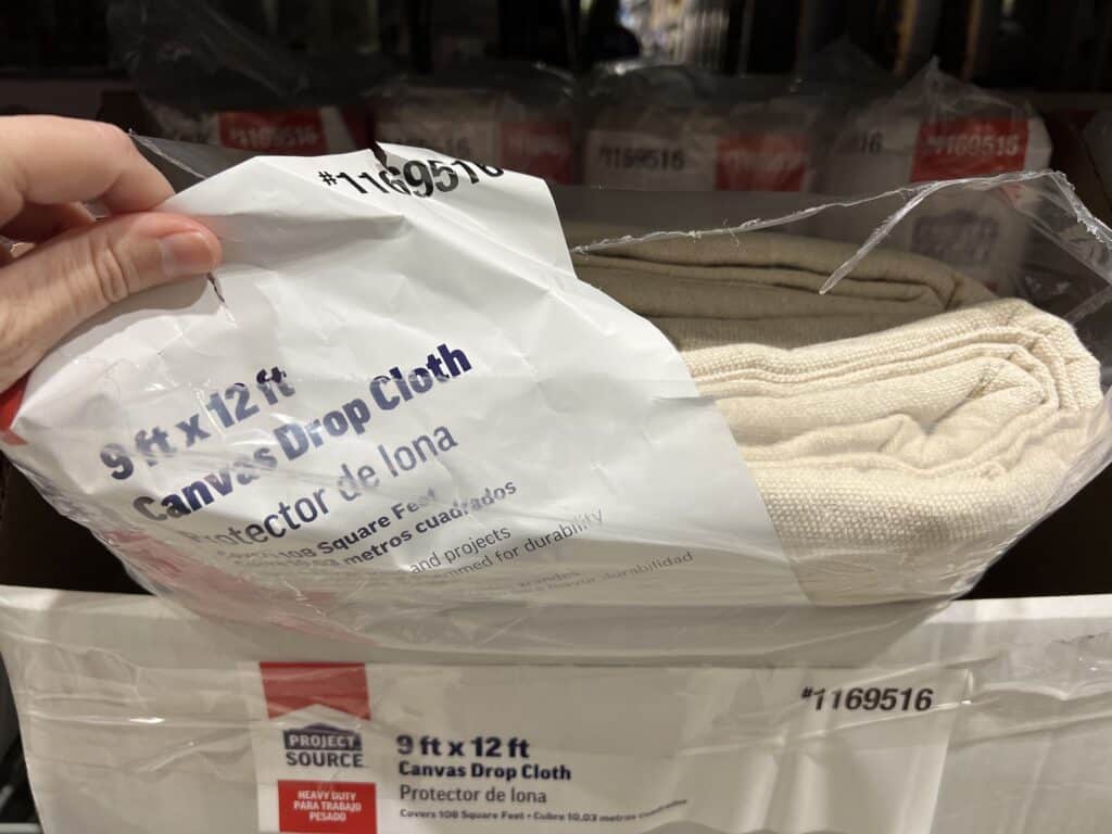 A person is holding a box of towels in a store.