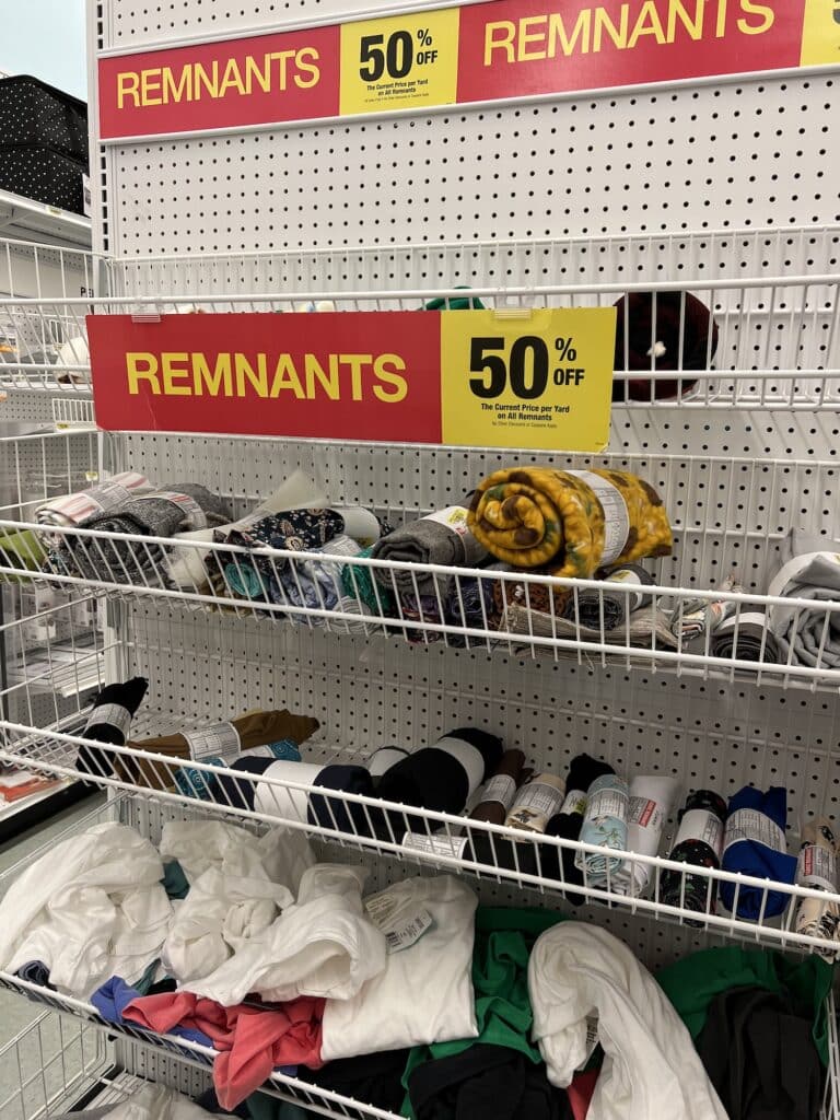 A rack of clothes in a store with a sign that says remanants.