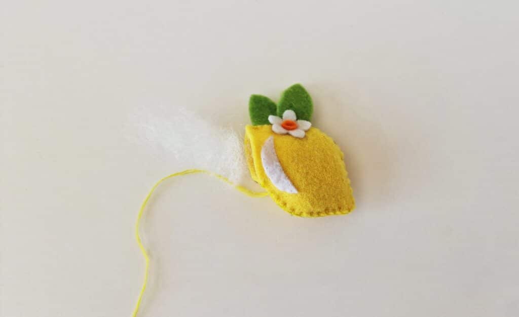 Felt Lemon Step 8 -A felt pineapple with a flower attached to a string.