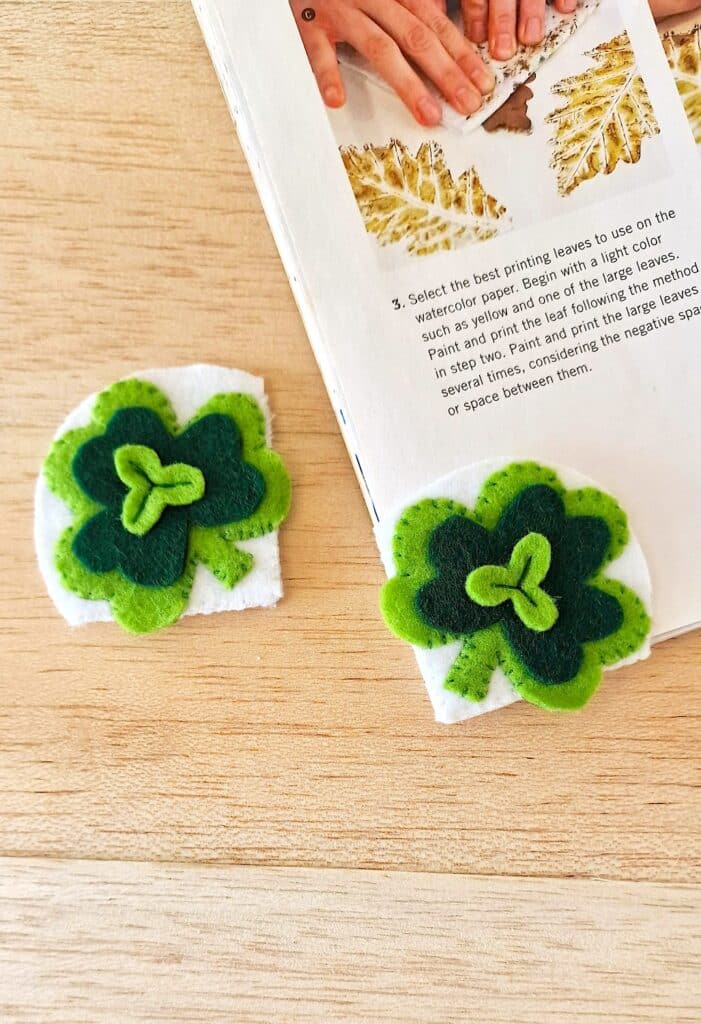 Two felt shamrock bookmarks on top of a book.