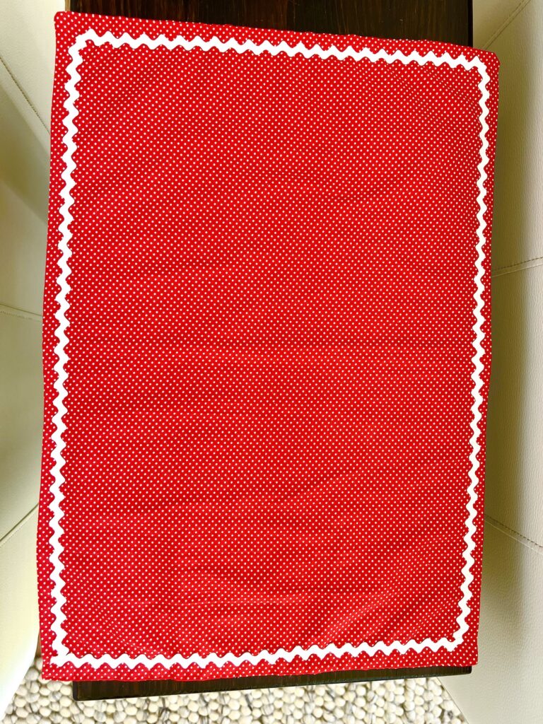 A red and white rick rack placemat on a table.