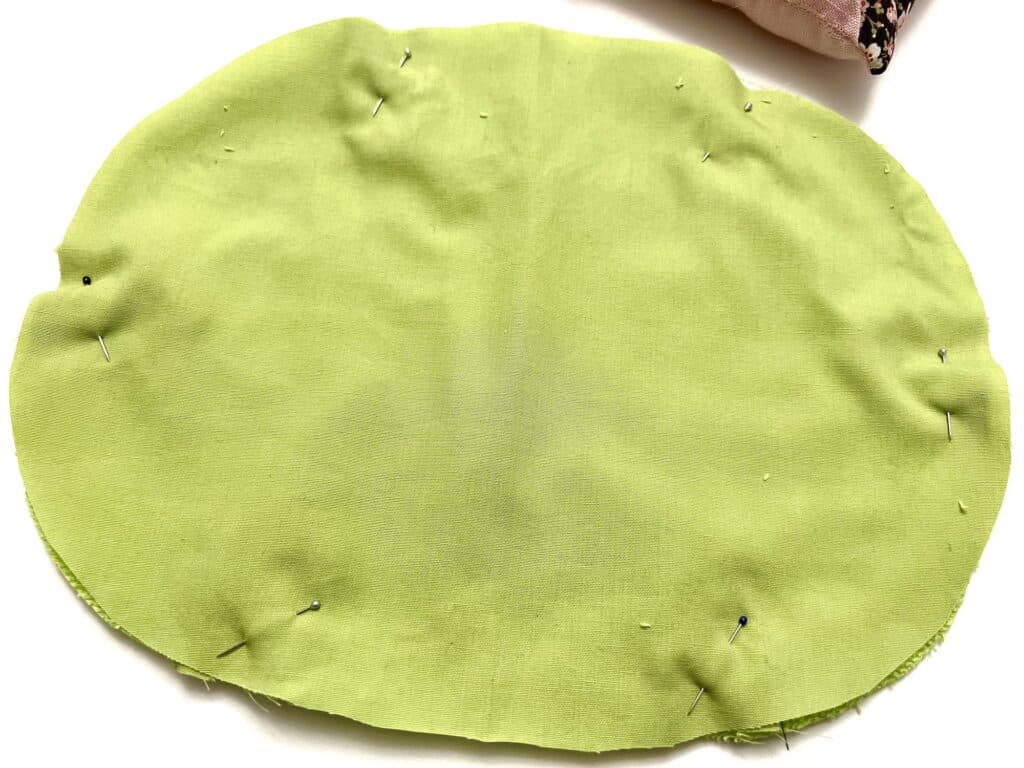 A green and pink pillow on a white surface.