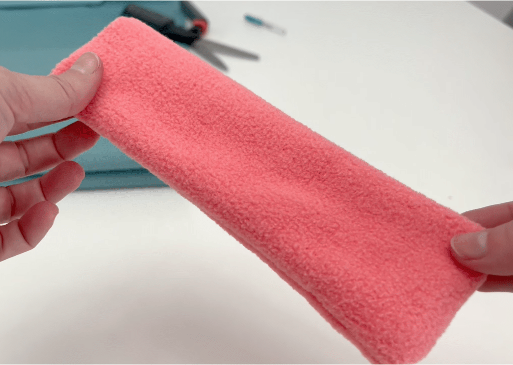 A person is holding a pink towel.
