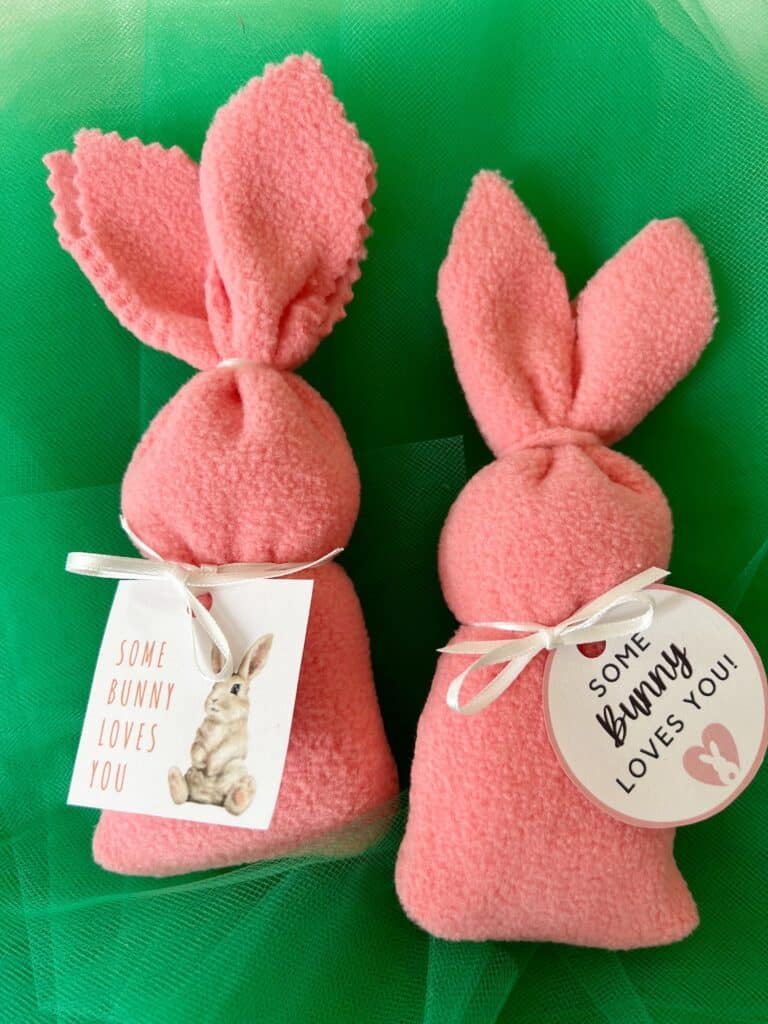 Two pink bunny bags with tags on them.