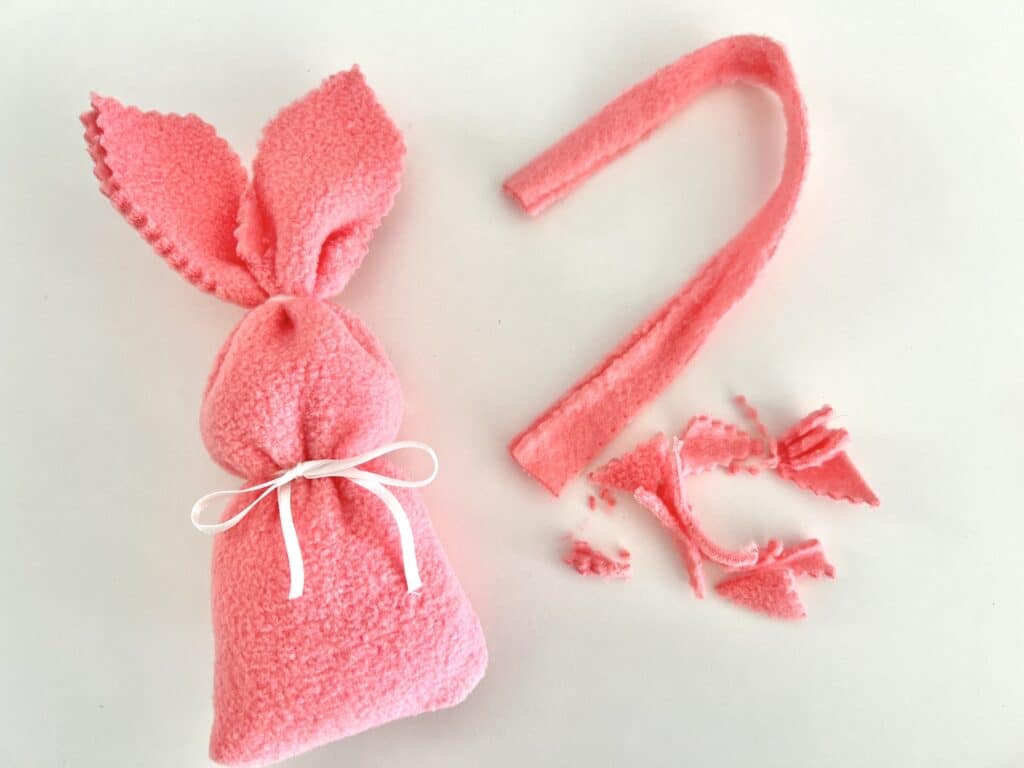 A pink felt bunny bag with a ribbon tied around it.