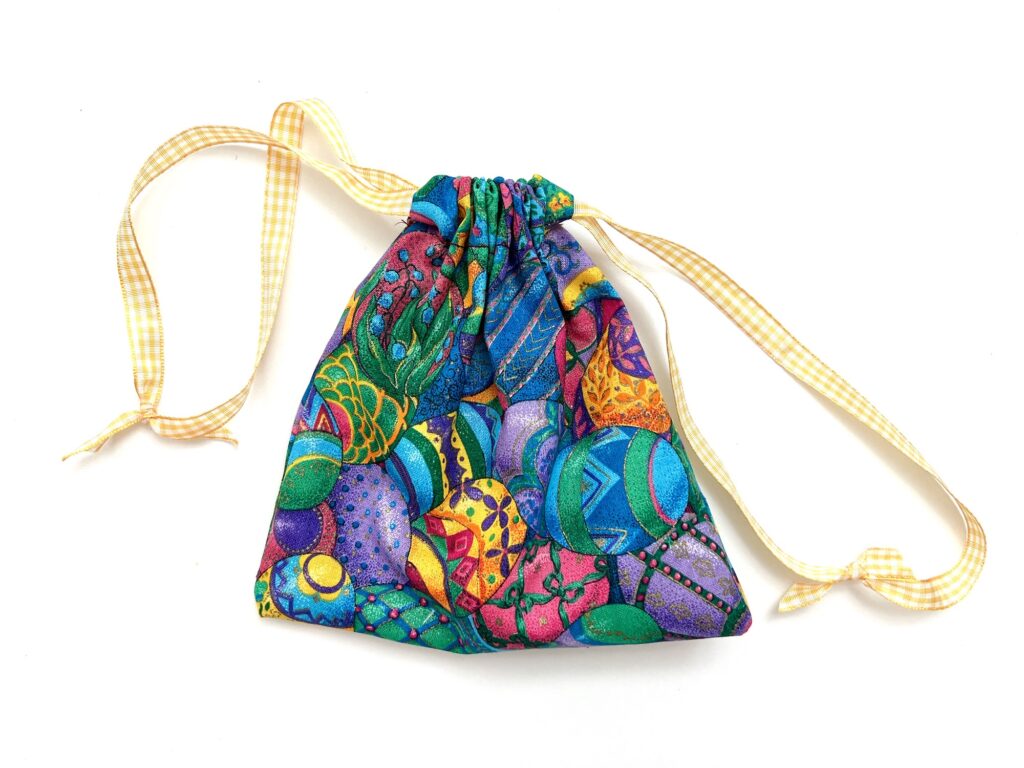 A colorful crayon bag with a yellow ribbon on a white background.