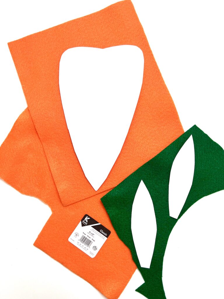 An assortment of colored felt fabric pieces with a heart shape cut out and a leaf shape design on a white background.