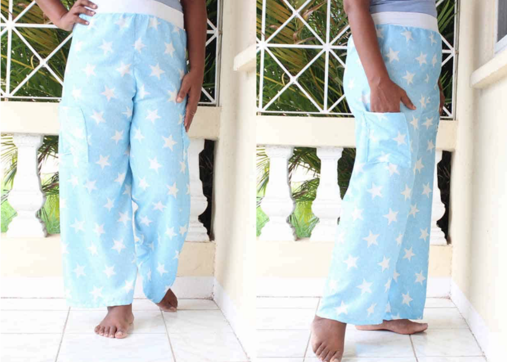 Person wearing light blue star-patterned pajama pants on a balcony with a white railing.