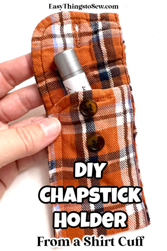 A hand holds a chapstick holder crafted from an orange plaid shirt cuff, complete with buttons and a snug spot for the chapstick inside.