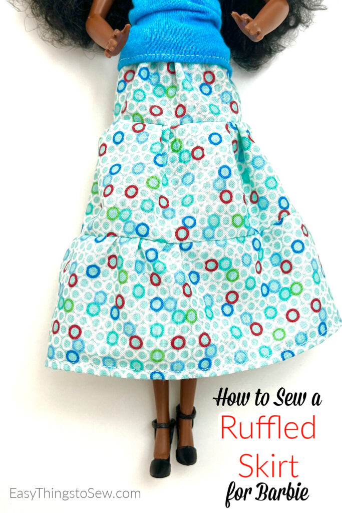 A doll wearing a blue top and a multicolored, patterned ruffled skirt. The image includes text: "How to Sew a Ruffled Skirt for Barbie.