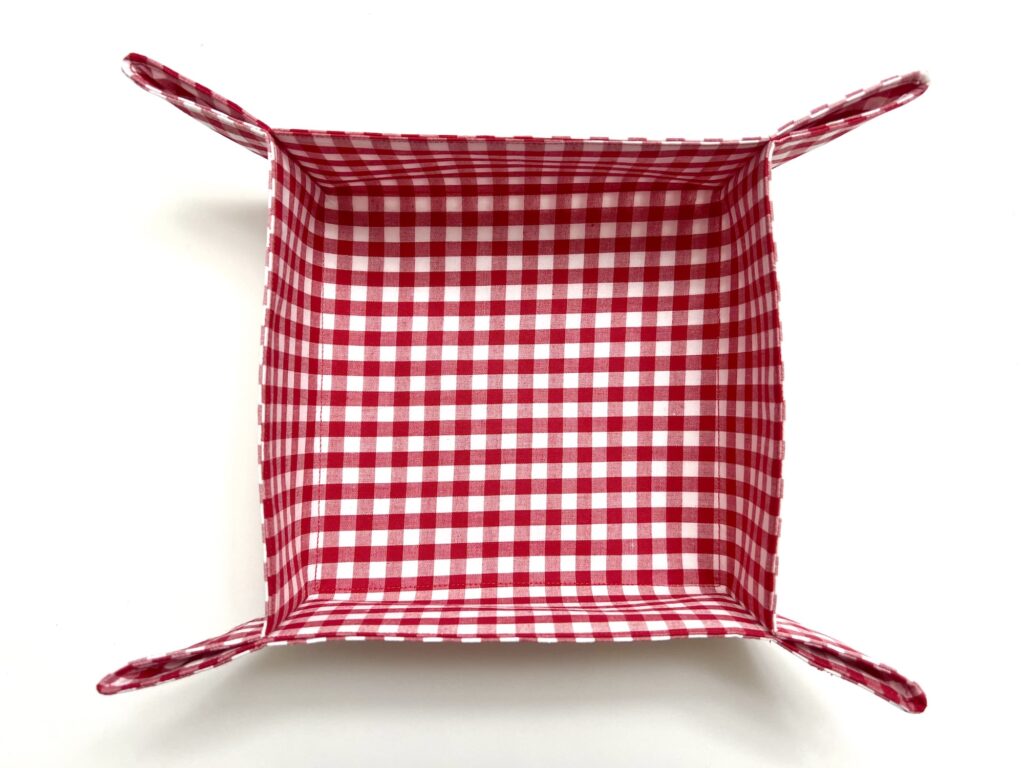 A rectangular fabric basket with red and white gingham check pattern, photographed from above on a white background.